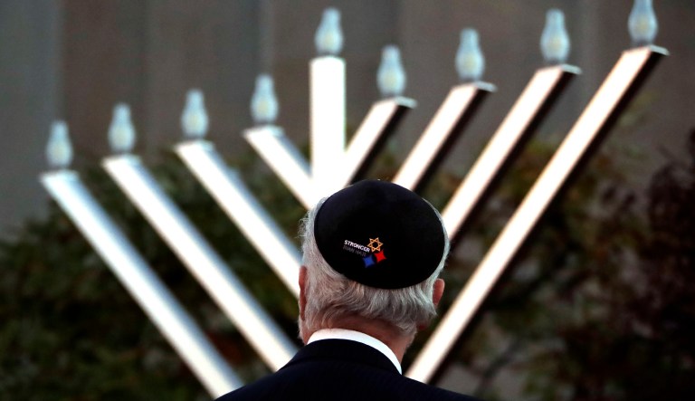 Rabbi Jeffrey Myers watches the installation of a menorah outside the Tree of Life Synagogue before holding a celebration on the first night of Hanukkah, Sunday, Dec. 2, 2018, in the Squirrel Hill neighborhood of Pittsburgh. A gunman shot and killed 11 people while they worshipped Saturday, Oct. 27, at the temple.