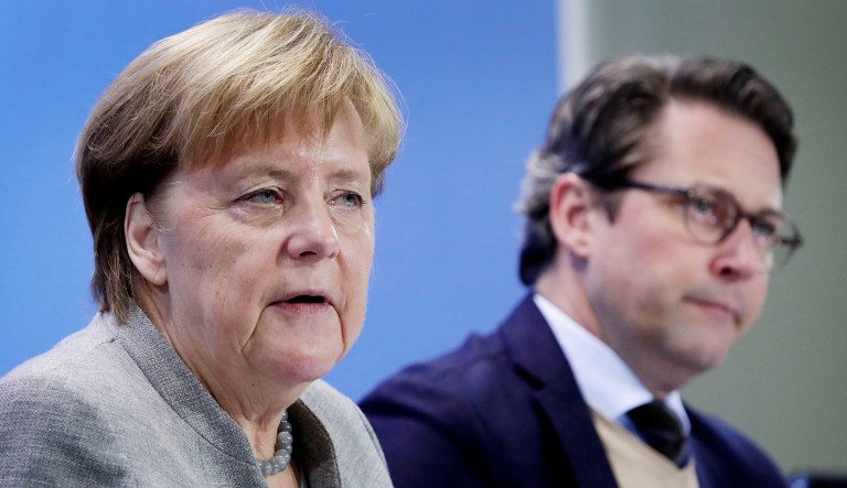 German Chancellor Angela Merkel, left, and German Transportation Minister Andreas Scheuer, right, address the media during a press conference at the chancellery in Berlin, Germany, Monday, Dec. 3, 2018 after a meeting with representatives of German cities that are affected by nitrogen oxide limit violations. 