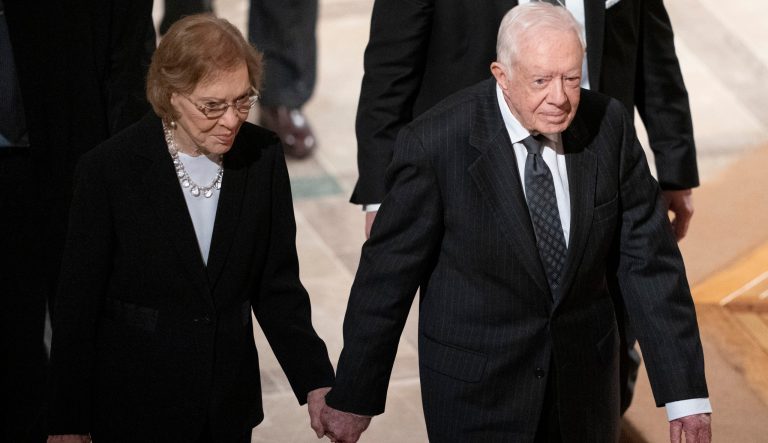 Former President Jimmy Carter, and Rosalynn Carter hold hands as they walk from a State Funeral for former President George H.W. Bush at the National Cathedral, Wednesday, Dec. 5, 2018, in Washington. 