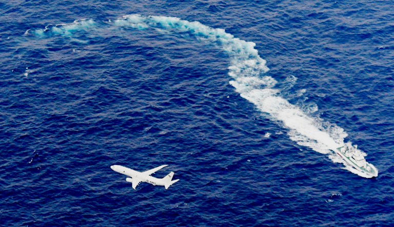 Japan's Coast Guard ship, top, and U.S. military plane are seen at sea off Kochi, southwestern Japan, during a search and rescue operation for missing crew members of a U.S. Marine refueling plane and fighter jet. The U.S. Marine Corps have declared that five crewmembers dead after their aircraft crashed last week off Japanâs southern coast and that their search has ended.
