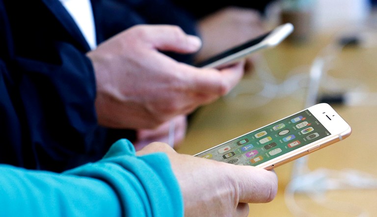 People look at smartphones.