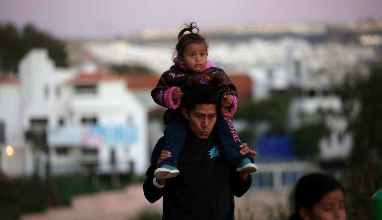 Honduran migrants walk away after failing to cross over the U.S. border wall to San Diego, California, from Playas in Tijuana, Mexico, Wednesday, Dec. 12, 2018.