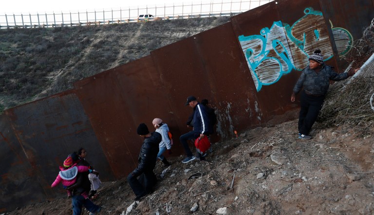 Honduran migrants walk away after failing to cross over the U.S. border wall to San Diego, California, from Playas in Tijuana, Mexico, Wednesday, Dec. 12, 2018.