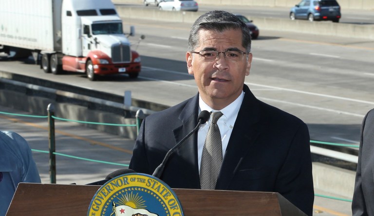 FILE - In this Oct. 26, 2018 file photo, California Attorney General Xavier Becerra, center, discusses a Trump administration plan to freeze vehicle emissions standards during a news conference in Sacramento, Calif. Becerra was joined by California Air Resources Board Chairperson Mary Nichols, and Gov. Jerry Brown. Becerra immediately became perhaps the nationâs most influential attorney general when he was named Californiaâs top lawyer two years ago. 
