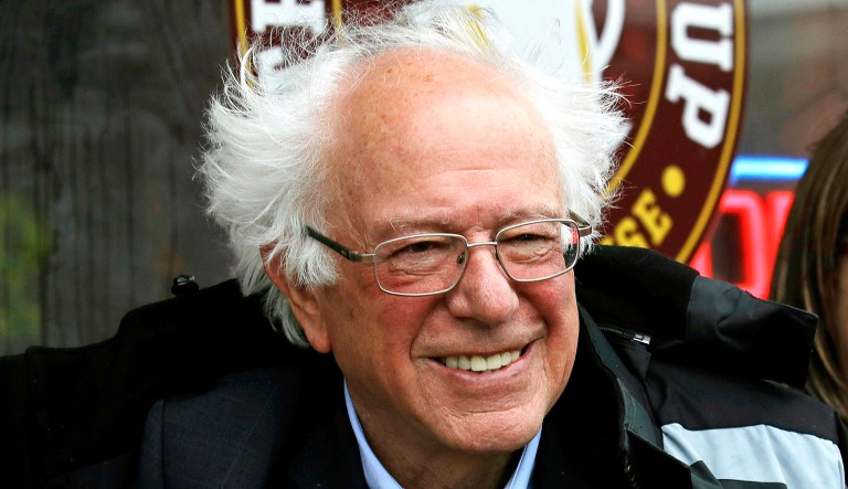Sen. Bernie Sanders, I-Vt., left, smiles at an event.