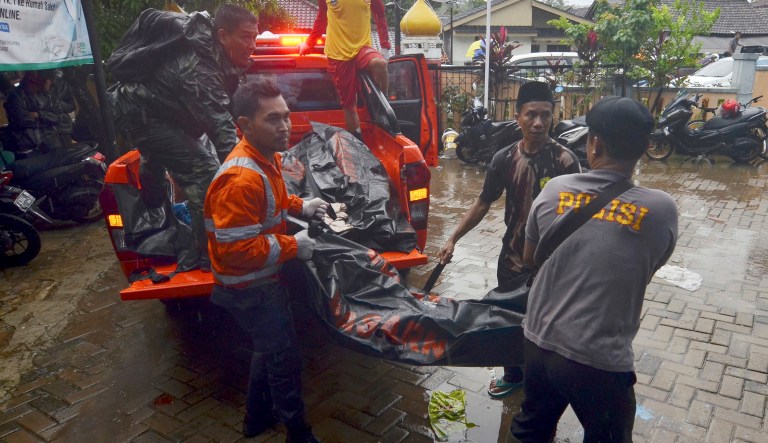 Rescuers remove a plastic bag containing the body of a tsunami victim from the back of a truck in Carita, Indonesia, Sunday, Dec. 23, 2018. The tsunami occurred after the eruption of a volcano around Indonesia's Sunda Strait during a busy holiday weekend, sending water crashing ashore and sweeping away hotels, hundreds of houses and people attending a beach concert.