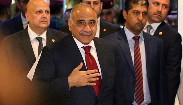 In this Oct. 24, 2018, file photo, then Prime Minister-designate Adel Abdul-Mahdi, center, arrives to the parliament building, in the heavily guarded Green Zone, in Baghdad, Iraq. 