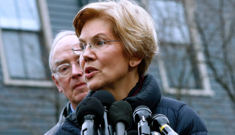 Sen. Elizabeth Warren, D-Mass., speaks beside her husband Bruce Mann, left, outside their home, Monday, Dec. 31, 2018, in Cambridge, Mass., where she confirmed that she is launching an exploratory committee to run for president. Warren on Monday took the first major step toward launching a widely anticipated campaign for the presidency, hoping her reputation as a populist fighter can help her navigate a Democratic field that could include nearly two dozen candidates.