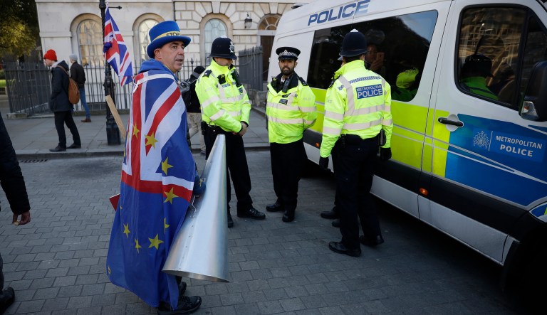 A demonstrator faces police outside parliament in London, Tuesday Jan. 8, 2019, as police react to a recent incident of verbal assaults by demonstrators on Conservative Party legislator Anna Soubry. The British government on Tuesday ruled out seeking an extension to the two-year period taking the country out of the European Union ahead of a crucial parliamentary vote next week on her Brexit deal.