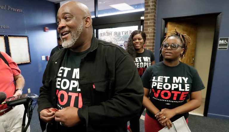 Former felon Desmond Meade and president of the Florida Rights Restoration Coalition, left, arrives with family members at the Supervisor of Elections office Tuesday, Jan. 8, 2019, in Orlando, Fla., to register to vote. Former felons in Florida began registering for elections when an amendment that restores their voting rights went into effect. 