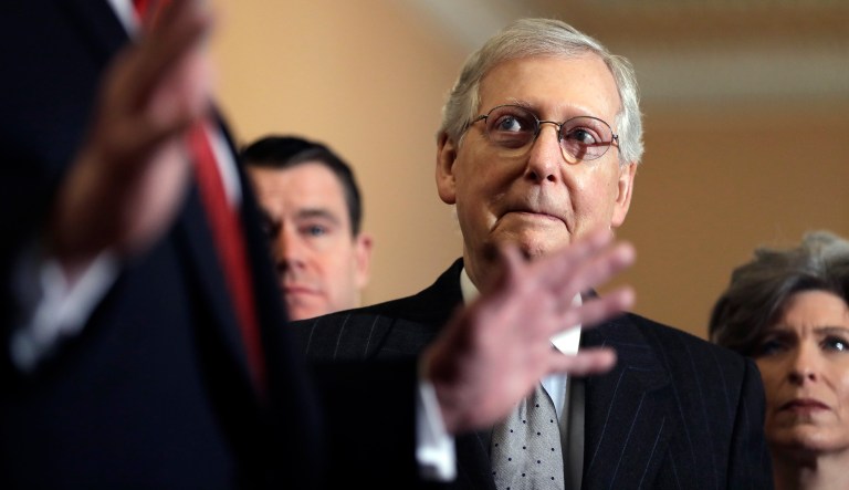 Senate Majority Leader Mitch McConnell of Kentucky listens as President Trump talks to the media after a Senate Republican policy lunch on Capitol Hill, Wednesday, Jan. 9, 2018, in Washington. At right is Sen. Joni Ernst, R-Iowa. 