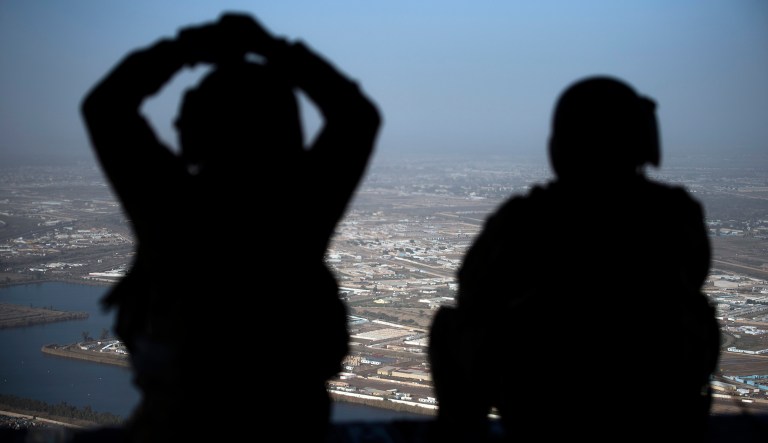 U.S. Army helicopter crew members look out of their Chinook helicopter as they fly from the U.S. Embassy to Baghdad International airport, following the helicopter of Secretary of State Mike Pompeo, over Baghdad, Iraqi, Wednesday, Jan. 9, 2019.