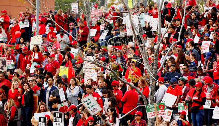 Teachers, parents, and students picket under the rain downtown Los Angeles on Friday.