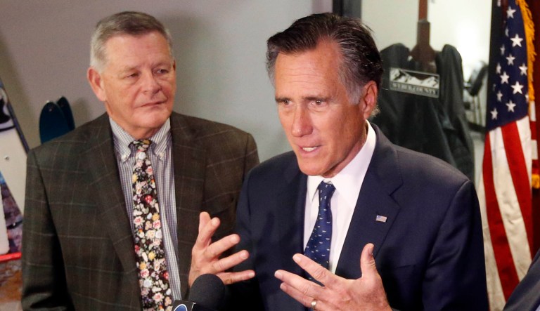 Sen. Mitt Romney, right, R-Utah, speaks with reporters.