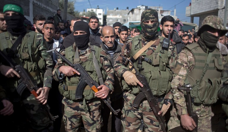 Masked Palestinian Hamas gunmen take part in the funeral of Hamas militant Mahmoud al-Nabahin, 24, in Buriej refugee camp, central Gaza Strip, Wednesday, Jan. 23, 2019. Israeli shelling of the Gaza Strip on Tuesday killed al-Nabahin and wounded four others shortly after an Israeli soldier was shot on the border of the coastal enclave, authorities said. Following the incident, Israel said it would halt a key transfer of Qatari funds to the Gaza Strip.