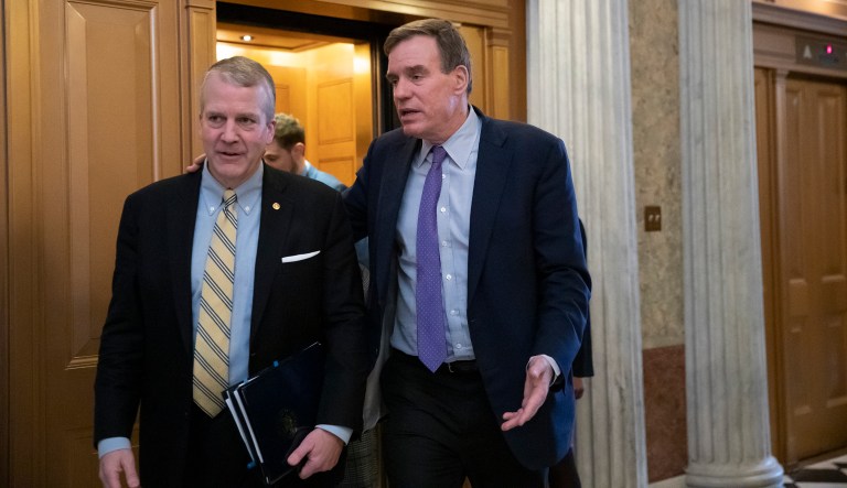 Sen. Dan Sullivan, R-Alaska, left, and Sen. Mark Warner, D-Va., the vice-chair of the Senate Intelligence Committee, arrive at the Senate prior to a vote on ending the partial government shutdown, at the Capitol in Washington, Thursday, Jan. 24, 2019.