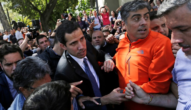 Opposition leader Juan Guaido is surrounded by supporters as he arrives to speak in a public plaza in Caracas, Venezuela.