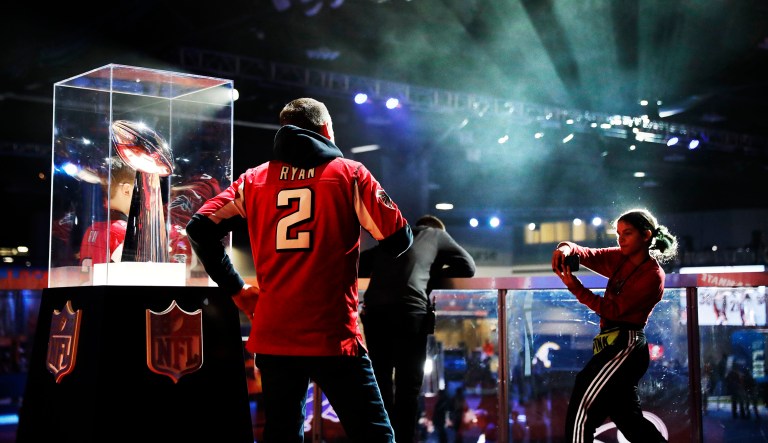 Fans have their photo taken with the Vince Lombardi Trophy at the NFL Experience ahead of Sunday's Super Bowl 53 football game between the Los Angeles Rams and New England Patriots in Atlanta, Wednesday, Jan. 30, 2019.