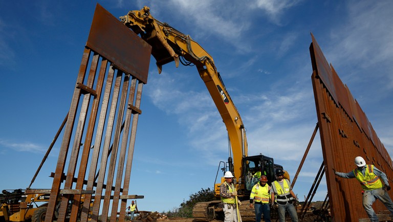 Construction crews install new border wall sections seen from Tijuana, Mexico.