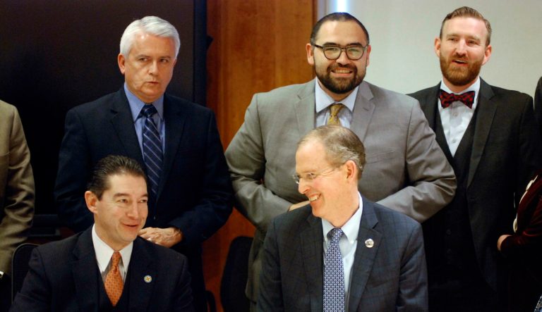 New Mexico state senators, including Democratic Majority Leader Peter Wirth, bottom right, react as New Mexico Gov. Michelle Lujan Grisham signs bills on Monday, Feb. 4, 2019, in Santa Fe, N.M. 