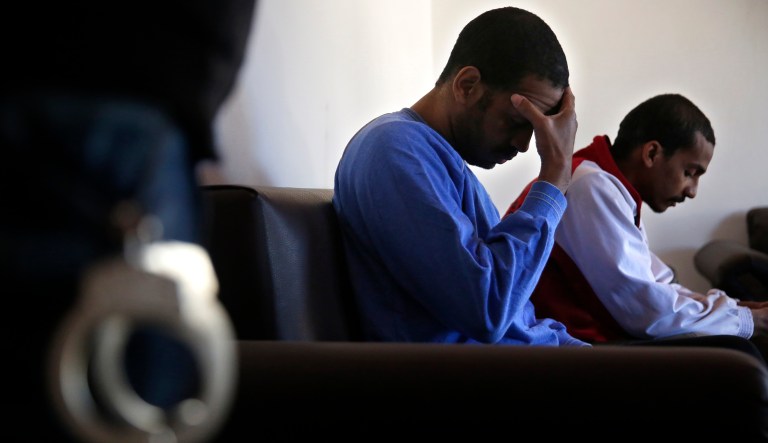 Alexanda Amon Kotey, center, and El Shafee Elsheikh, who were allegedly among four British jihadis who made up a brutal Islamic State cell dubbed "The Beatles," sit on a sofa at a security center in Kobani, Syria. 