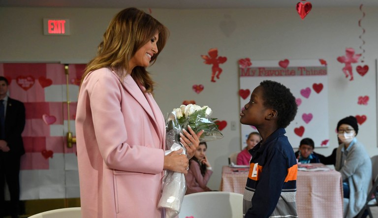 First lady Melania Trump is presented with a bouquet of flowers from Amani, 13, of Mombasa, Kenya, during her visit to the National Institutes of Health to see children at the Children's Inn in Bethesda, Md.