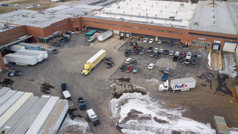 Law enforcement personnel gather at the scene of a shooting at an industrial park.