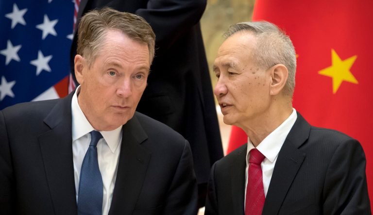 In this Feb. 15, 2019 photo, Chinese Vice Premier Liu He, right, talks with U.S. Trade Representative Robert Lighthizer, while they line up for a group photo at the Diaoyutai State Guesthouse in Beijing. 
