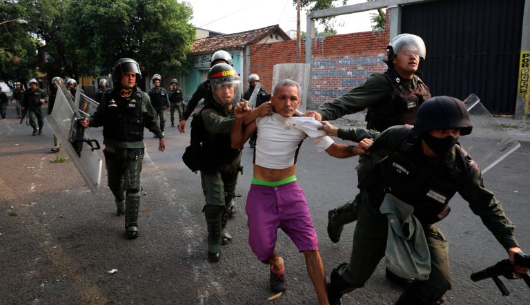 A man is detained during clashes with the Bolivarian National Guard in Urena, Venezuela, near the border with Colombia, Saturday, Feb. 23, 2019. Venezuela's National Guard fired tear gas on residents clearing a barricaded border bridge between Venezuela and Colombia on Saturday, heightening tensions over blocked humanitarian aid that opposition leader Juan Guaido has vowed to bring into the country over objections from President Nicolas Maduro. 