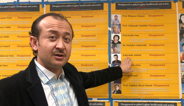 Abudwaris Ablimit points to a photo of his brother during a gathering to raise awareness about loved ones who have disappeared in China's far west, in Washington D.C. on Sunday, Feb. 24, 2019.