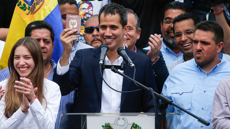 Venezuelan Congress President Juan Guaido, an opposition leader who declared himself interim president, shows his passport to supporters as he leads a rally demanding the resignation of Venezuelan President Nicolas Maduro.