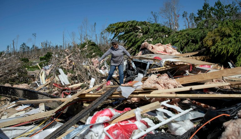 Cindy Sanford sifts through the debris while retrieving personal items after a tornado destroyed her home in Beauregard, Ala., Tuesday, March 5, 2019.