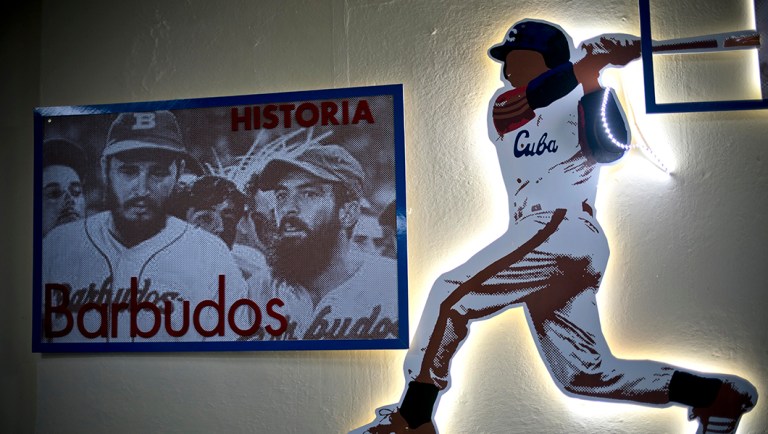 A photo hangs of Cuba's late leader Fidel Castro, left, with the late Camilo Cienfuegos, both wearing baseball uniforms during a game.
