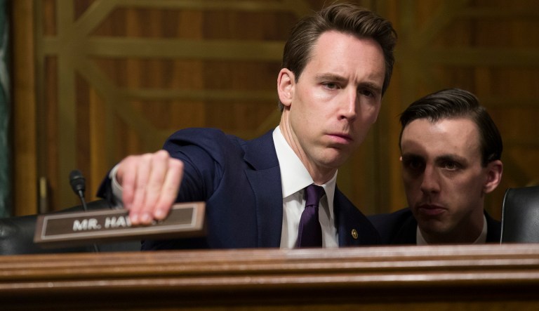 Sen. Josh Hawley, R-Mo., places his nameplate as he listens to an aide during a hearing of the Senate Judiciary Committee on oversight of Customs and Border Protection's response to the smuggling of persons at the southern border, Wednesday, March 6, 2019, in Washington.