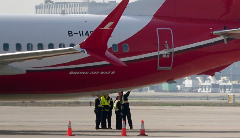 Ground crew chat near a Boeing 737 MAX 8 plane operated by Shanghai Airlines parked on tarmac at Hongqiao airport in Shanghai, China, Tuesday, March 12, 2019. 