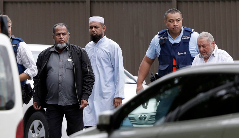 Police escort men from a mosque in central Christchurch, New Zealand, on Friday.