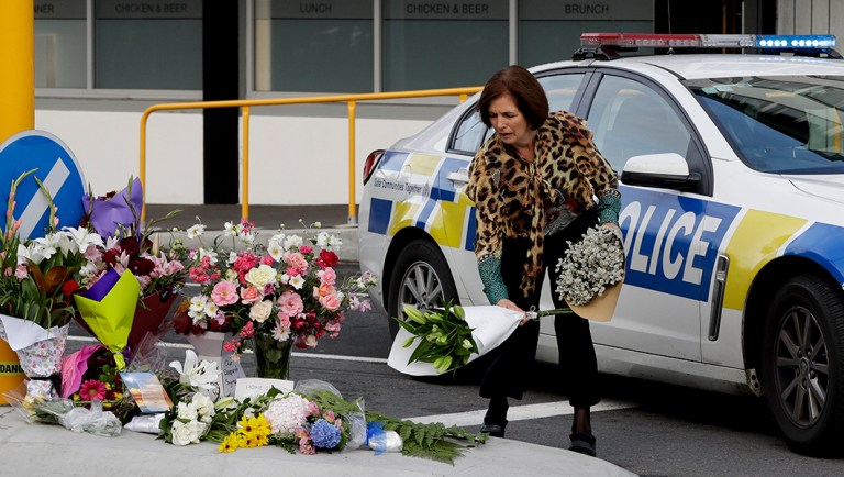 A woman places flowers at a makeshift memorial near the mosque in Christchurch, New Zealand.