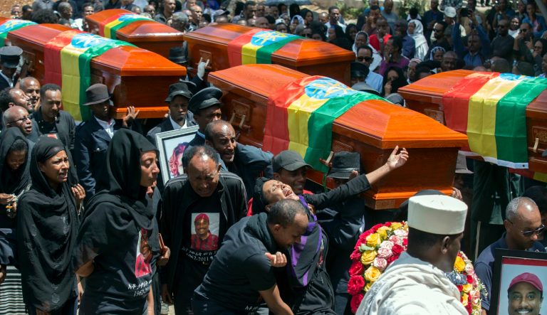 Relatives grieve next to empty caskets draped with the national flag at a mass funeral at the Holy Trinity Cathedral in Addis Ababa, Ethiopia Sunday, March 17, 2019. 