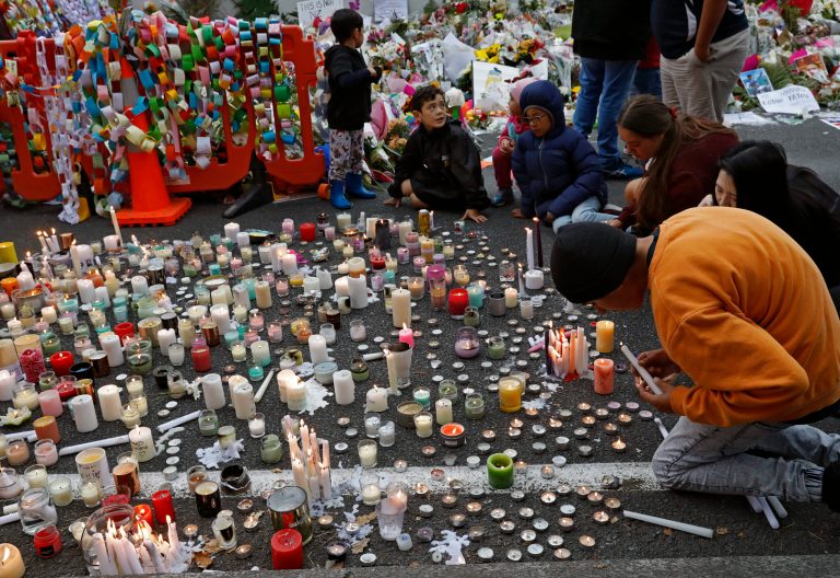 Students light candles as they gather for a vigil to commemorate victims.