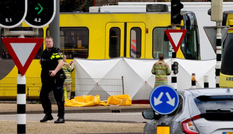 Rescue workers install a screen on the spot where a body was covered with a white blanket following a shooting in Utrecht, Netherlands, Monday, March 18, 2019. Police in the central Dutch city of Utrecht say on Twitter that "multiple" people have been injured as a result of a shooting in a tram in a residential neighborhood. 