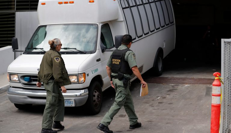 A van carrying asylum seekers from the border is escorted by security personnel as it arrives to immigration court, Tuesday, March 19, 2019, in San Diego. 