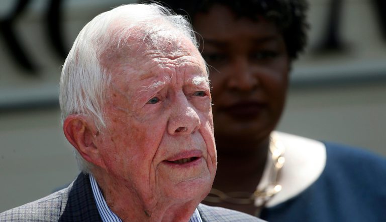 In this Sept. 18, 2018 photo, former President Jimmy Carter speaks as Democratic gubernatorial candidate Stacey Abrams listens during a news conference to announce her rural health care plan, in Plains, Ga. 