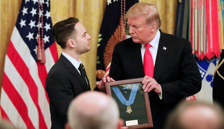 Trevor Oliver accepts the Medal of Honor from President Donald Trump, presented to his father, Army Staff Sgt. Travis Atkins in recognition for conspicuous gallantry in Iraq in June 2007, during a ceremony in the East Room of the White House, Wednesday March 27, 2019, in Washington.