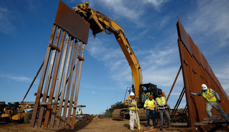 In this Jan. 9, 2019 photo, construction crews install new border wall sections seen from Tijuana, Mexico. The government is working on replacing and adding fencing in various locations, and Trump in February declared a national emergency to get more funding for the wall. 