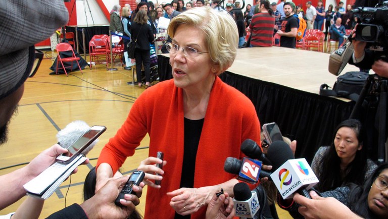 Sen. Elizabeth Warren, D-Mass., talks to reporters after a speech in a high school gymnasium in Reno, Nev.