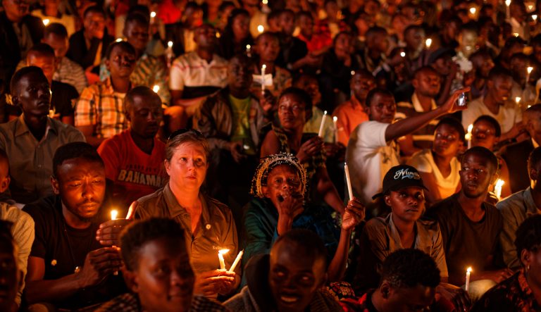 Rwandans and others sitting in the stands hold candles as part of a candlelit vigil during a memorial service held at Amahoro stadium in the capital Kigali, Rwanda Sunday, April 7, 2019. 
