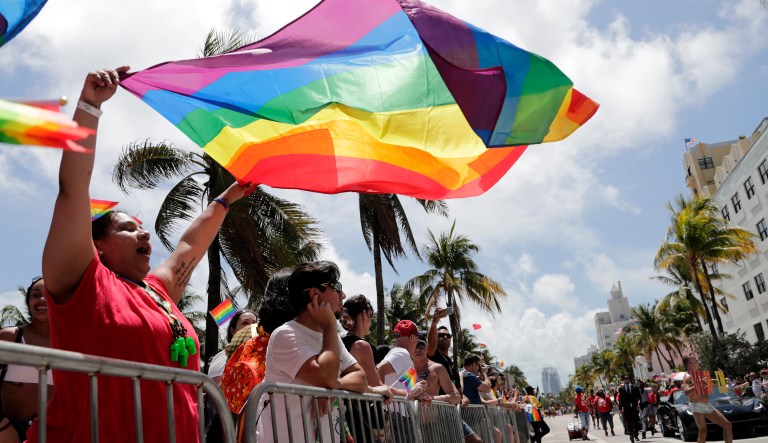 A woman waves a rainbow flag during the 11th annual Pride Parade along Ocean Drive, as part of Miami Beach Pride week, Sunday, April 7, 2019, in Miami Beach, Fla.
