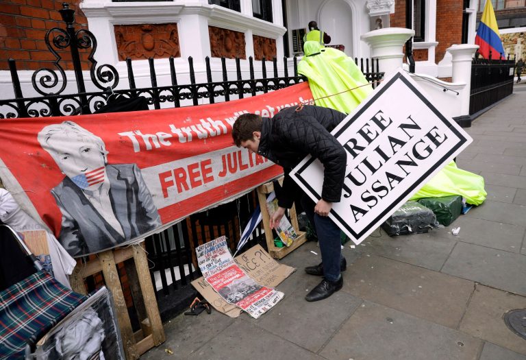 A protester holds a placard outside the Ecuadorian Embassy in London, after WikiLeaks founder Julian Assange was arrested by officers from the Metropolitan Police and taken into custody Thursday April 11, 2019.