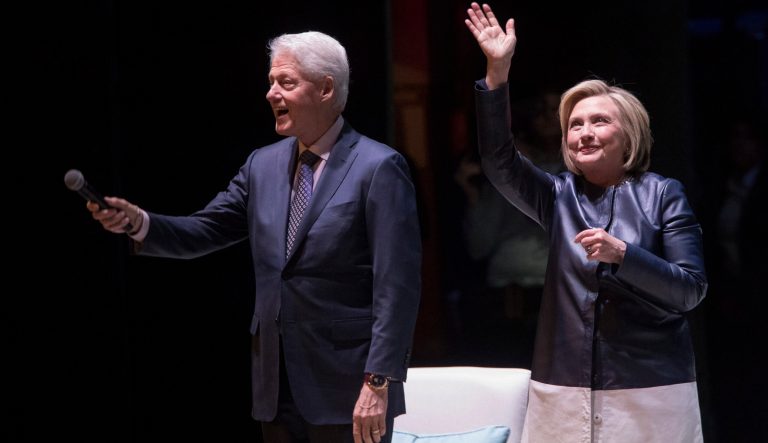 Former President Bill Clinton, left, and former Secretary of State Hillary Rodham Clinton wave at the crowd.