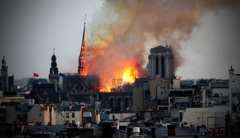 Flames rise from Notre Dame cathedral as it burns in Paris, Monday. Massive plumes of yellow brown smoke is filling the air above Notre Dame Cathedral and ash are falling on tourists and others around the island that marks the center of Paris. 